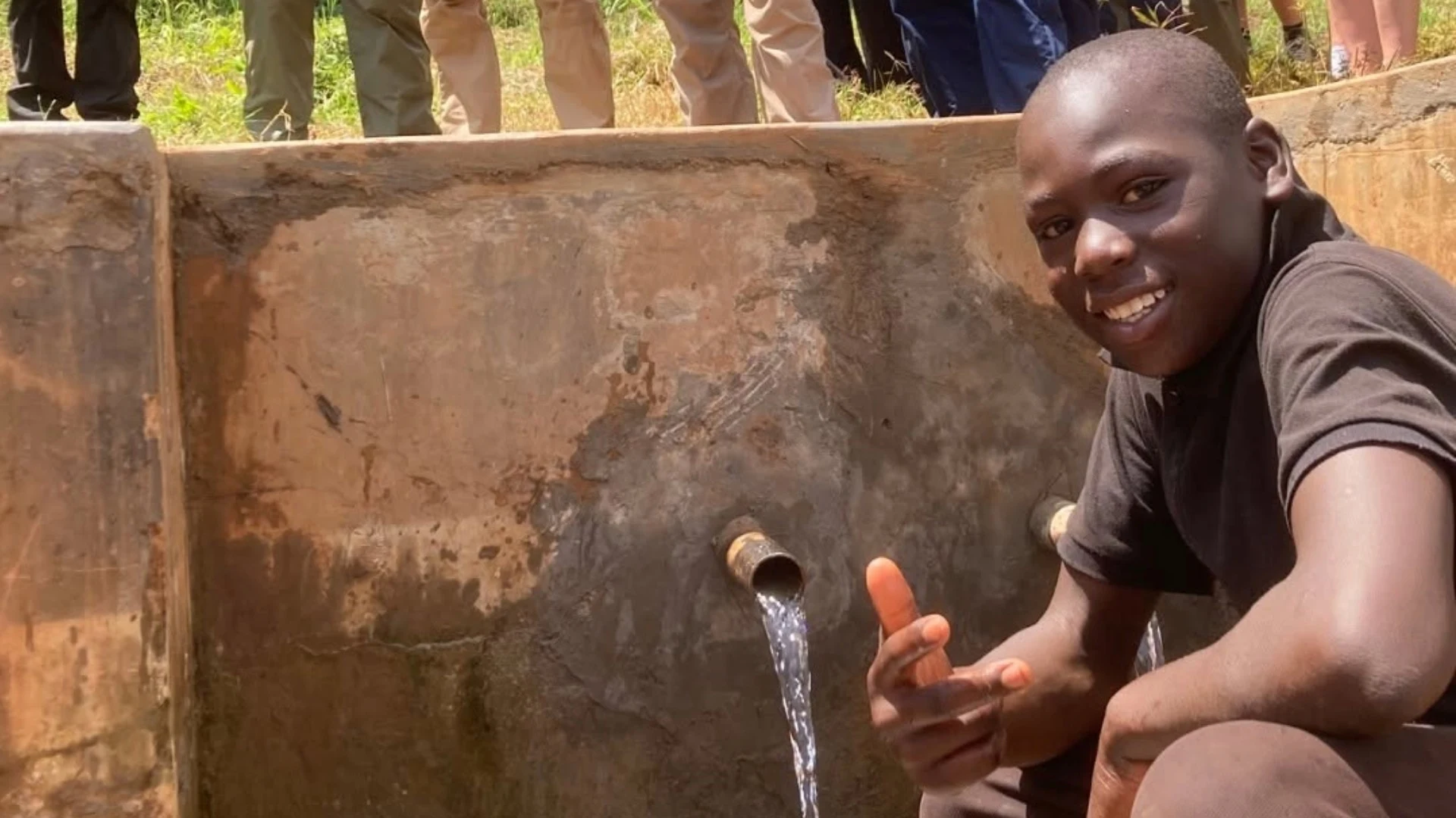 A local boy in front of a water spout in Kenya.