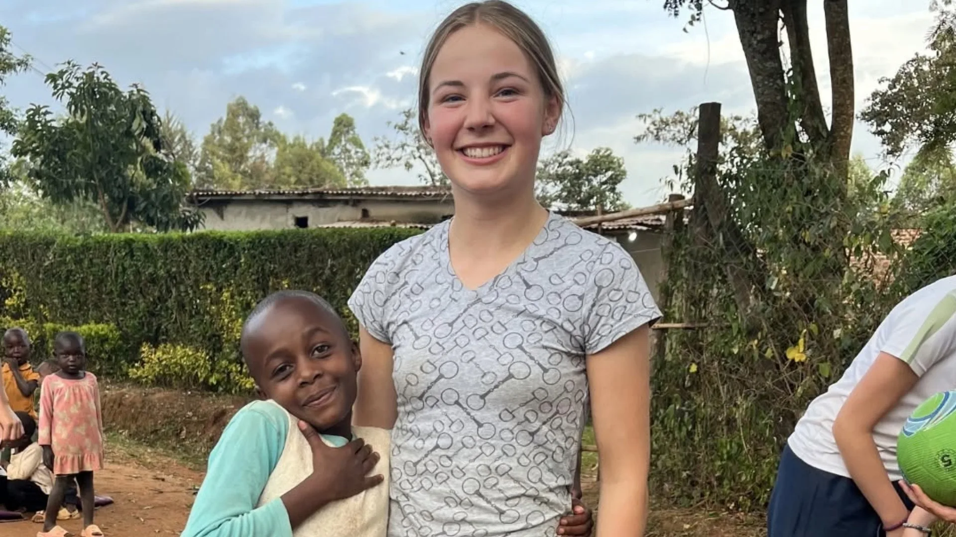 A local girl hugs a Barney student on the Kenya expedition.