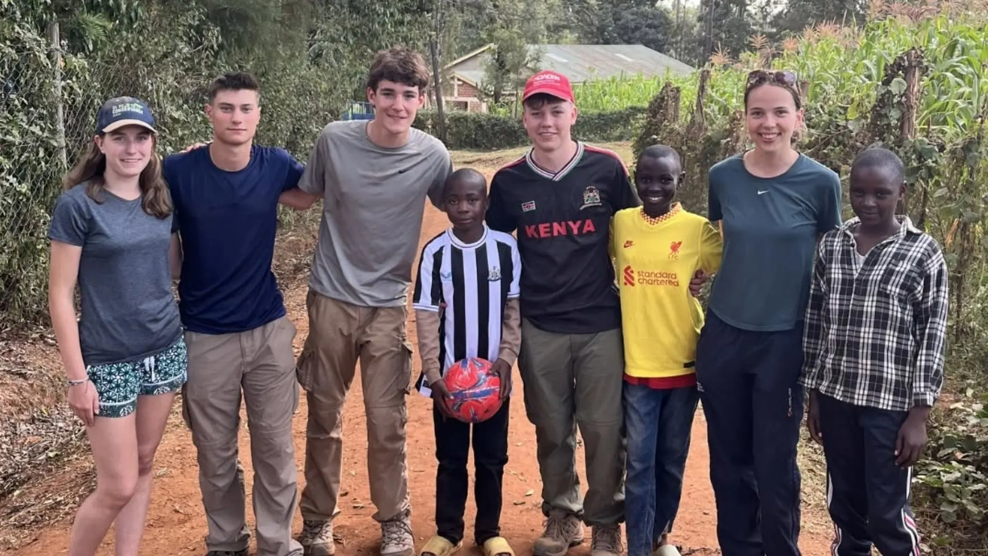 Barney students standing with local boys in Kenya.