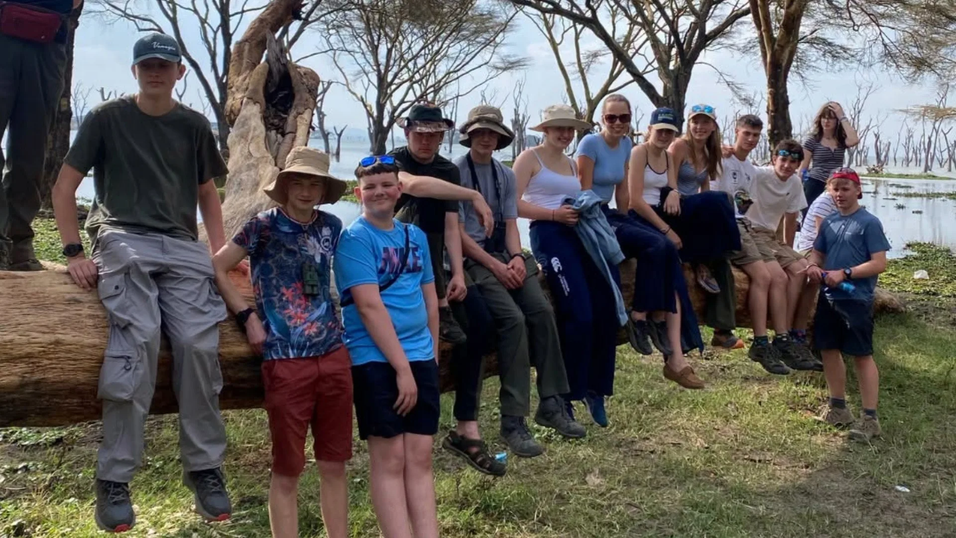 Barney students sitting together on a log in Kenya.