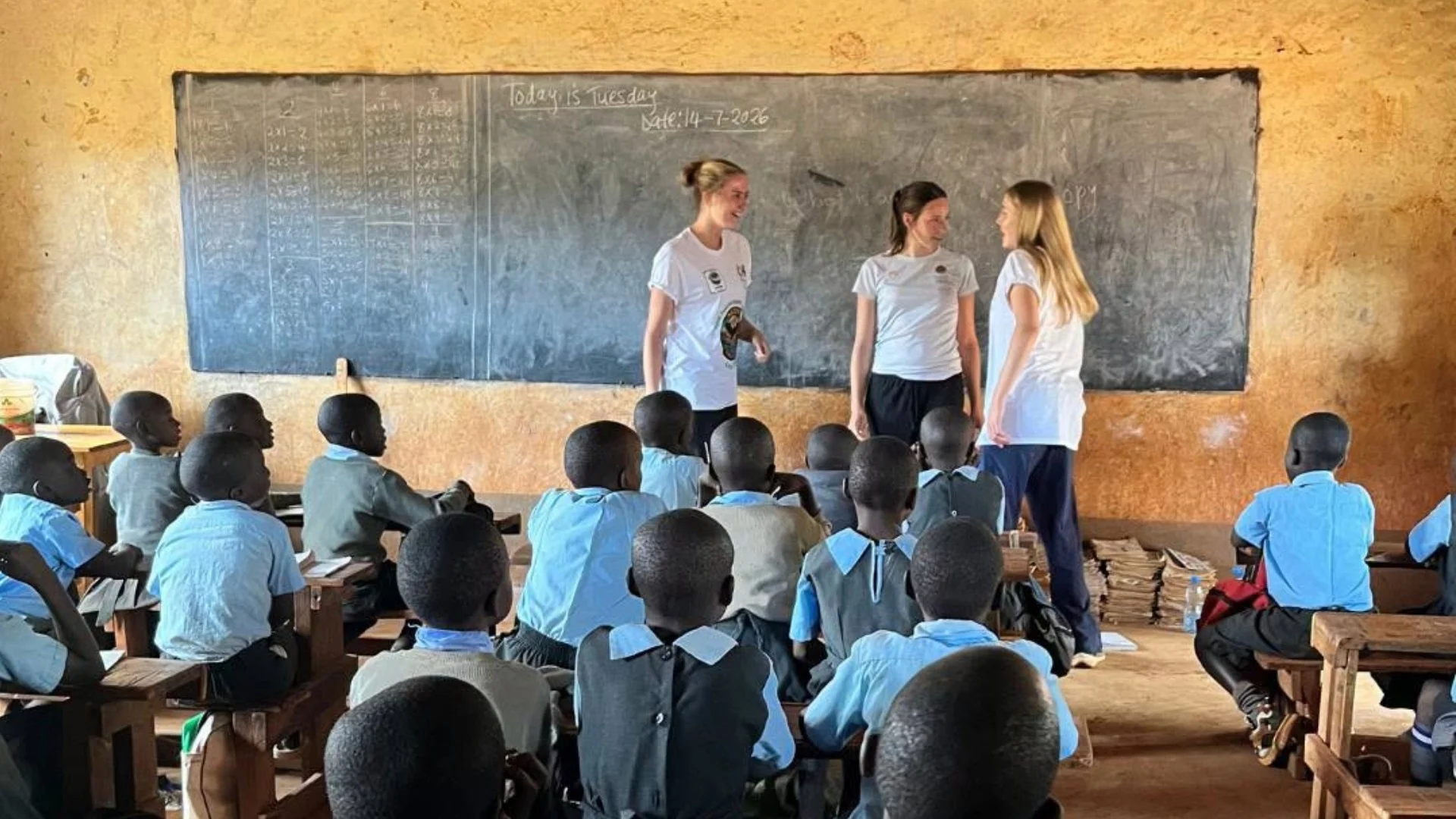 Barney students in front of a blackboard in a classroom in Kenya.
