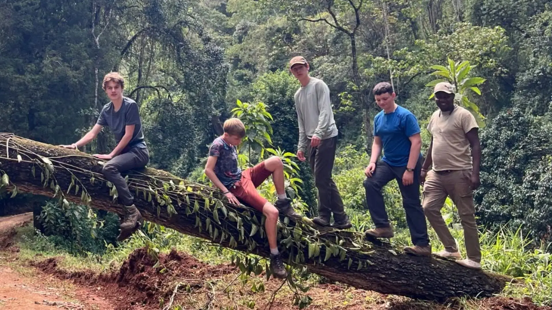 Barney students climbing a large log in Kenya.