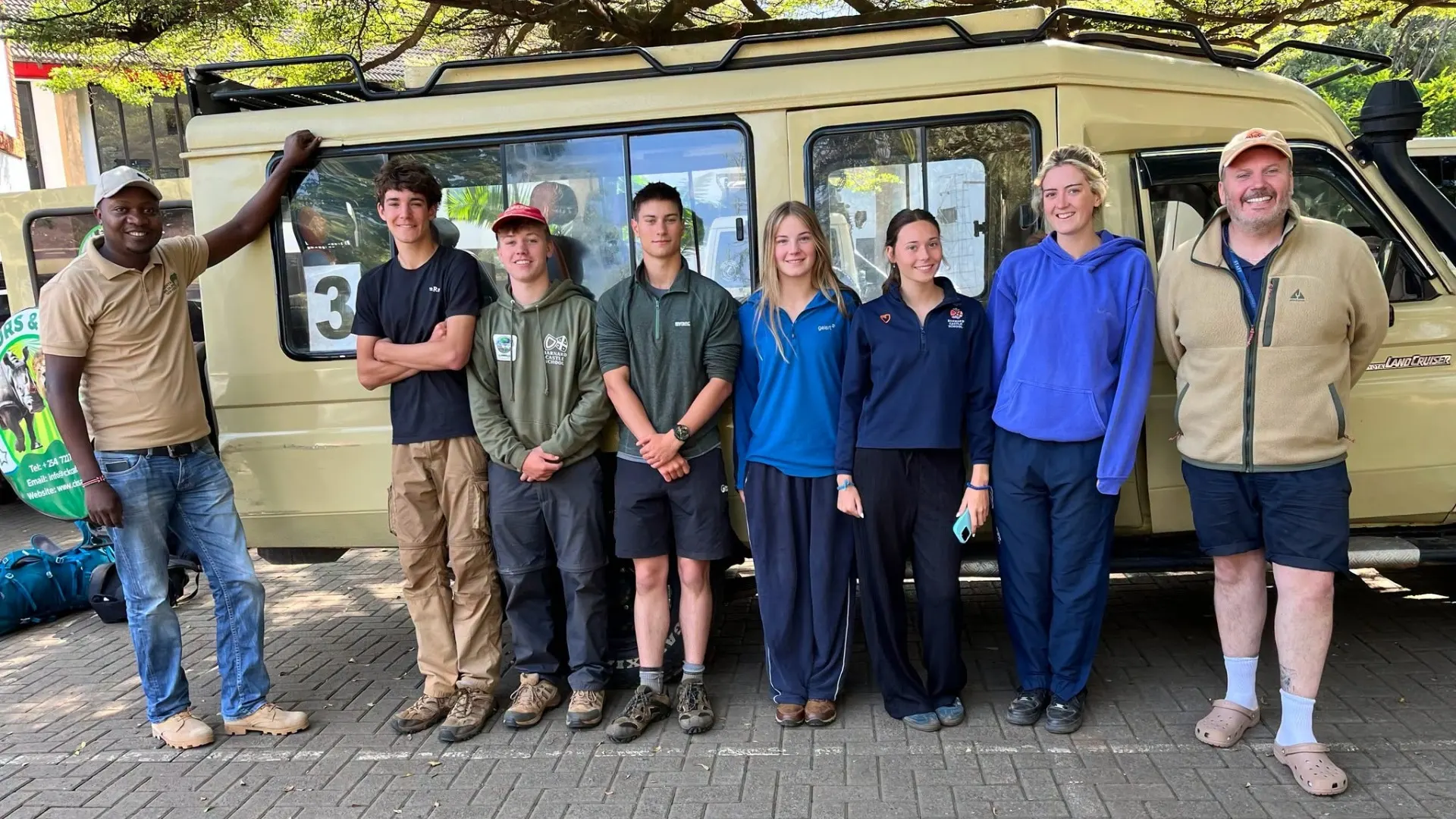 Barney students in front of a safari vehicle.