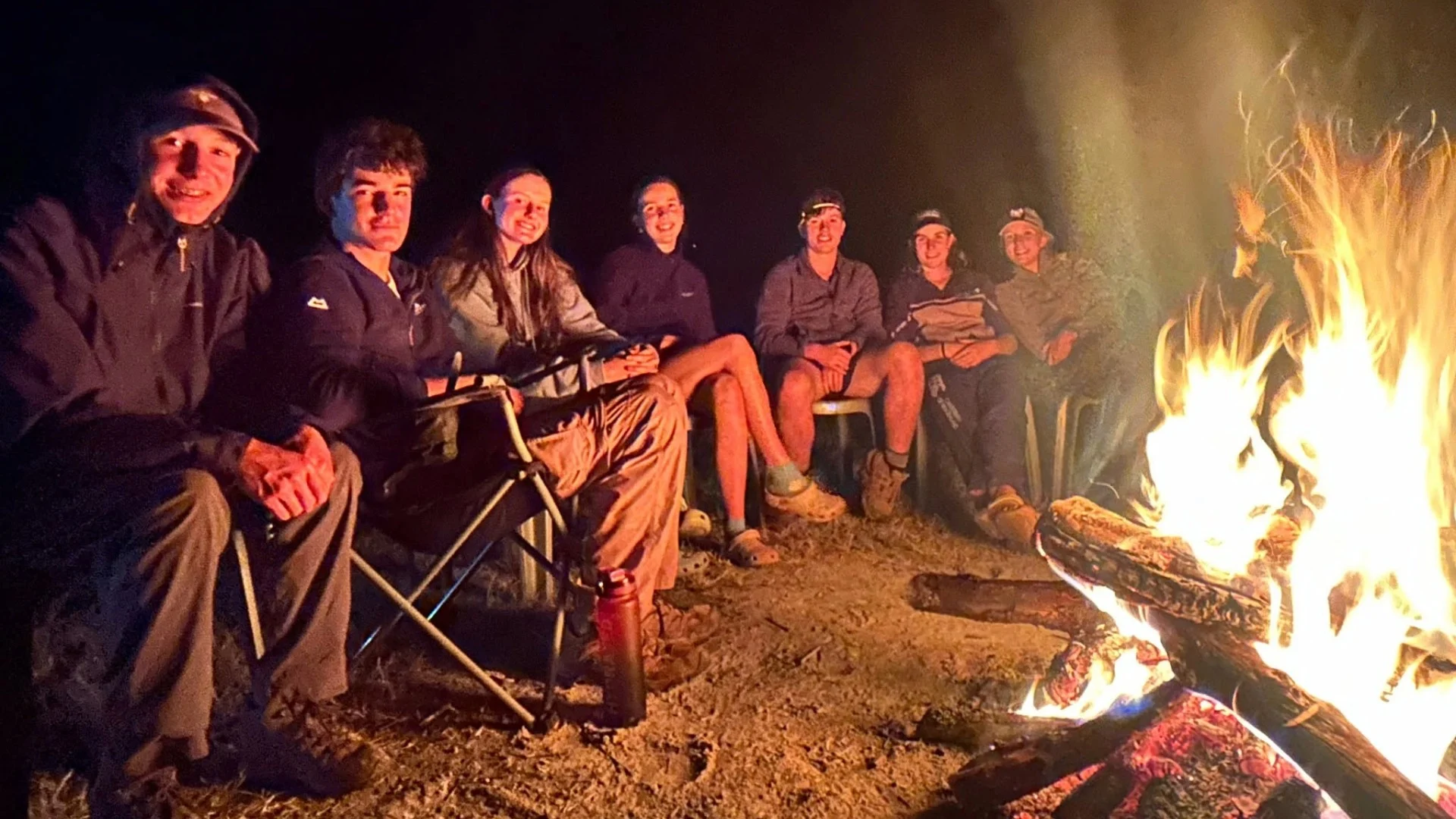 Barney students gathered around a campfire.