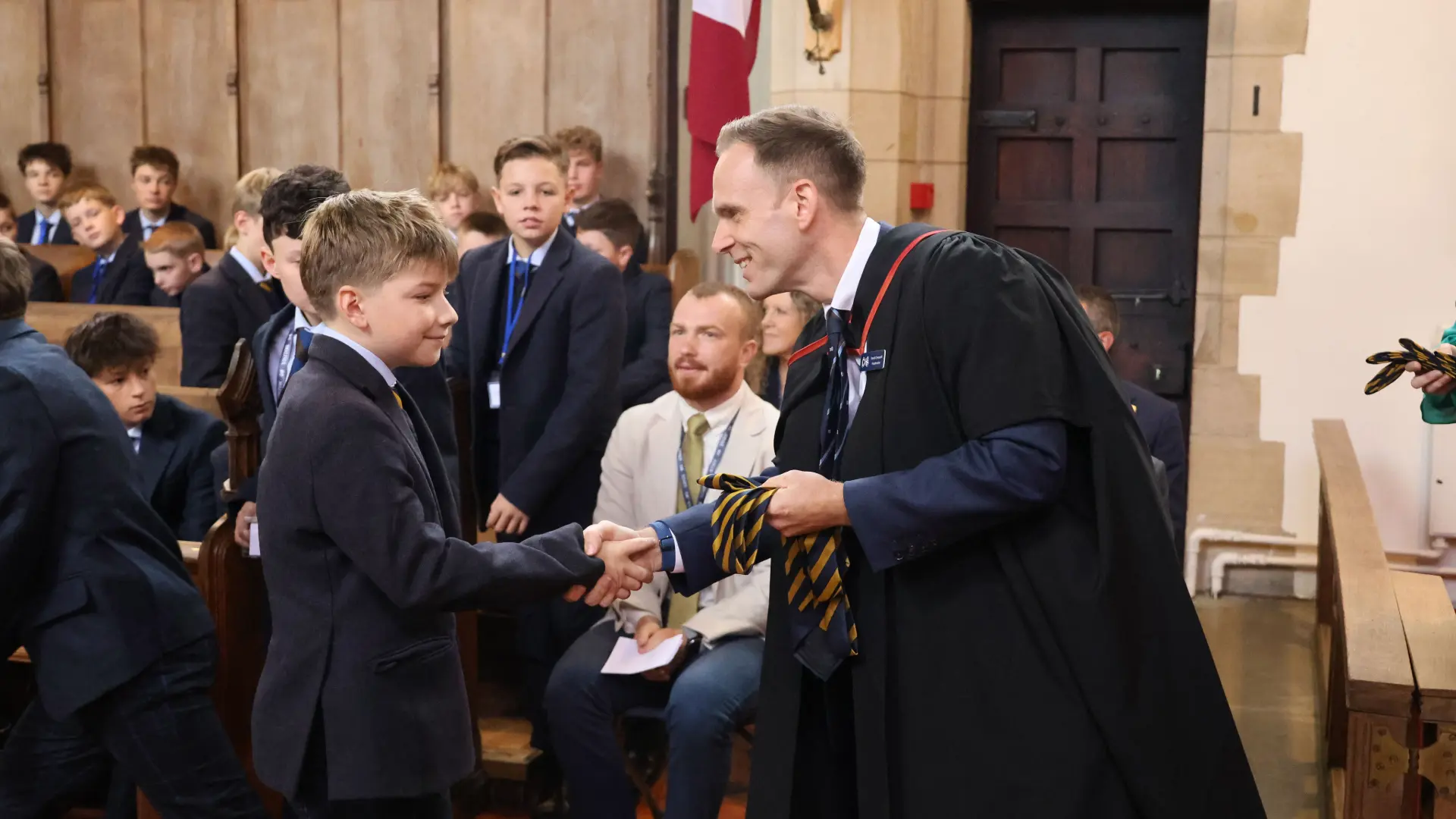 Headmaster shaking students hand during welcome assembly