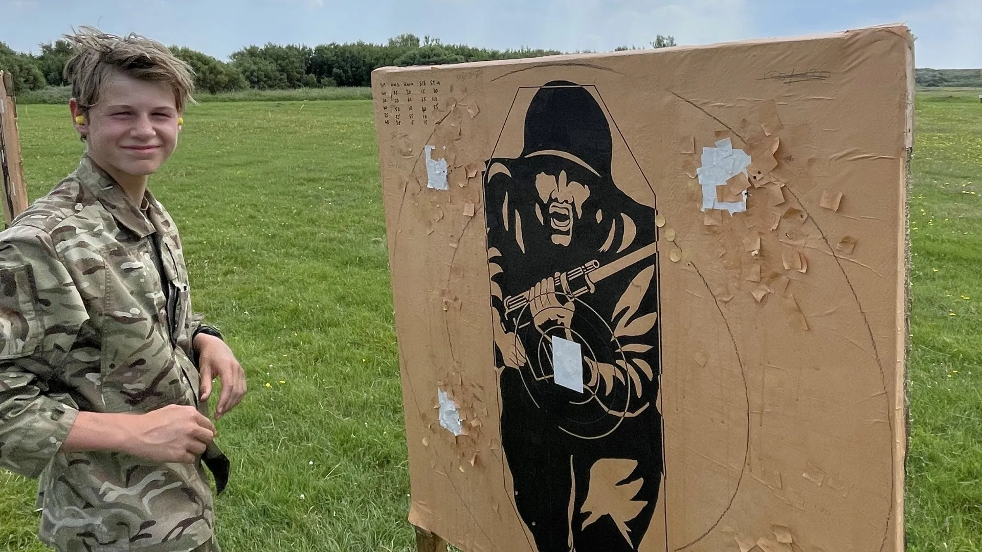 A Barney CCF cadet standing next to a target board.