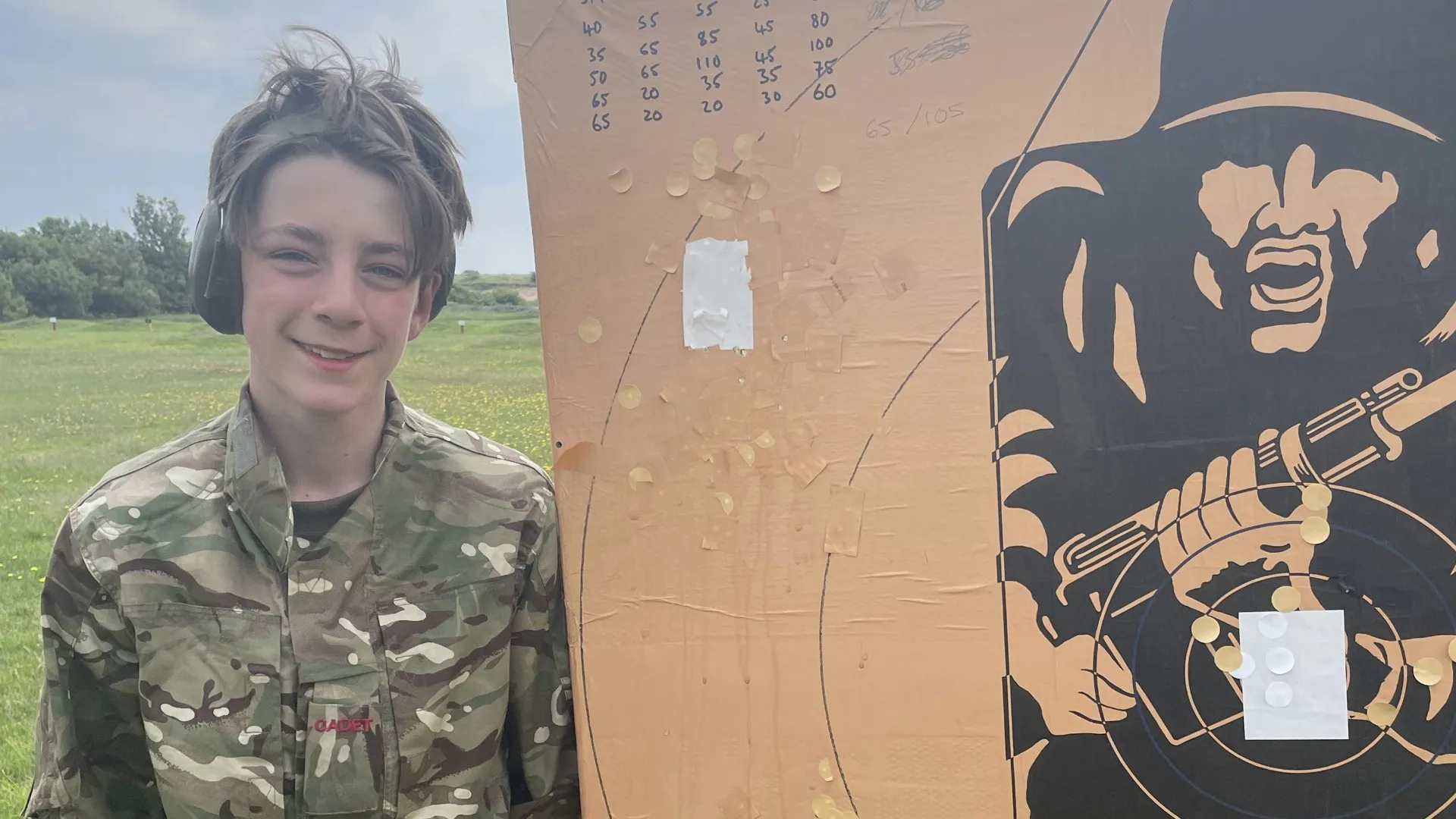 A Barney CCF cadet standing next to a target board.