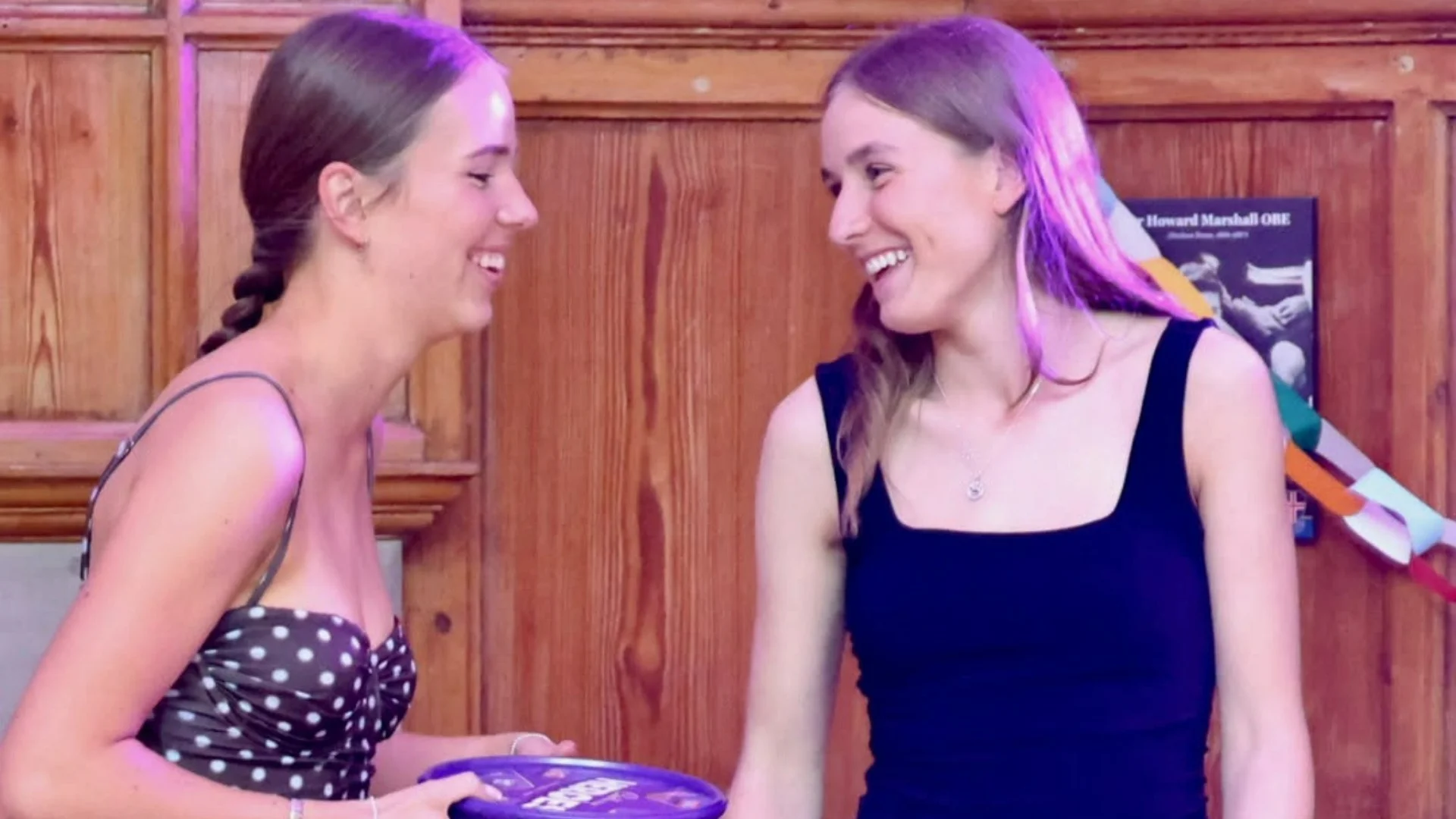 Barney Sixth Formers laughing in formalwear, holding a box of Celebrations.
